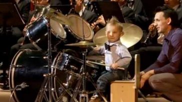 Photo of adorable three year old playing the drums.