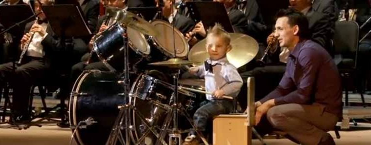 Photo of adorable three year old playing the drums.