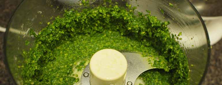Photo of pesto being made in a food processor.